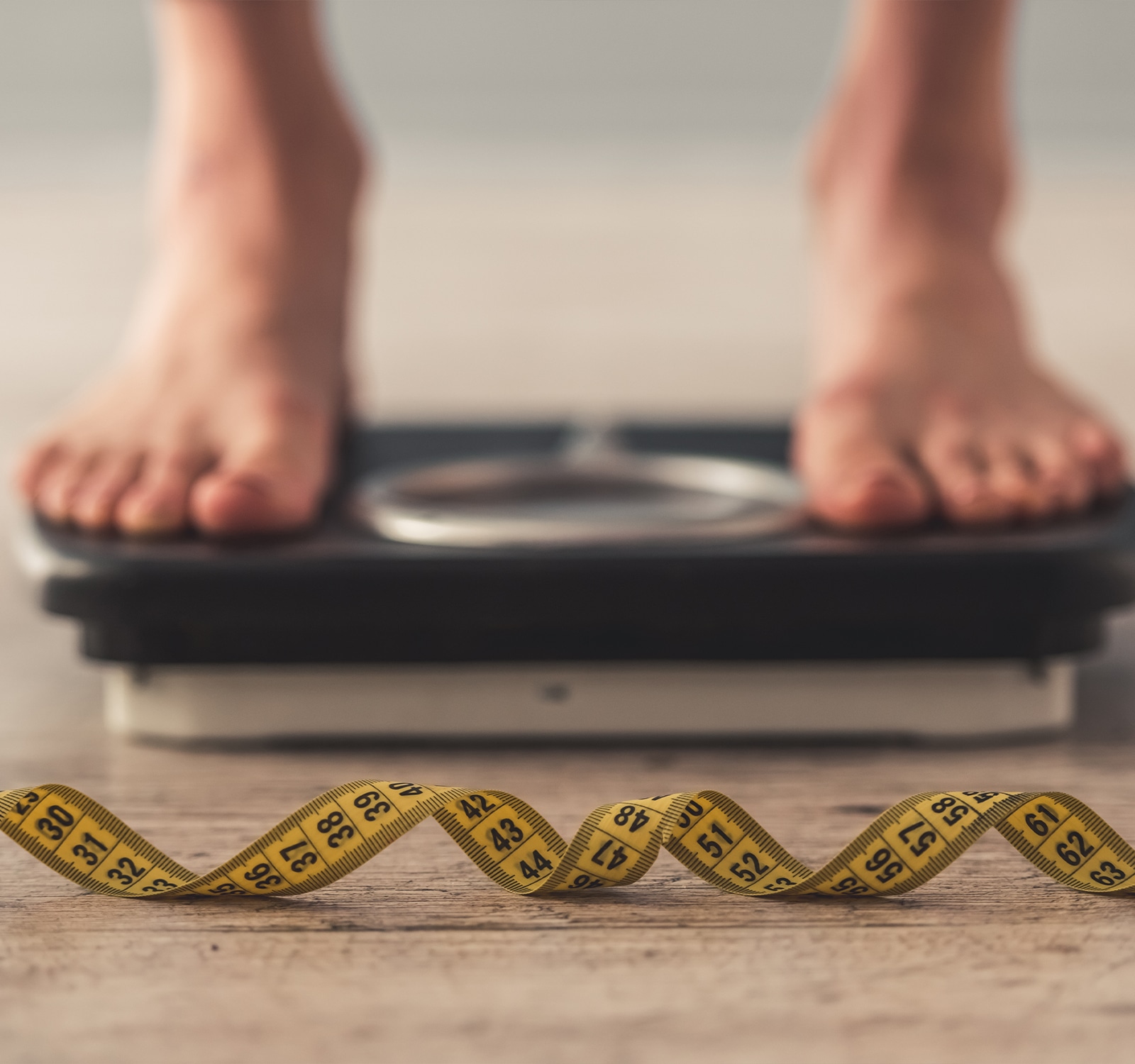 Measuring tape and feet on a scale in the background.